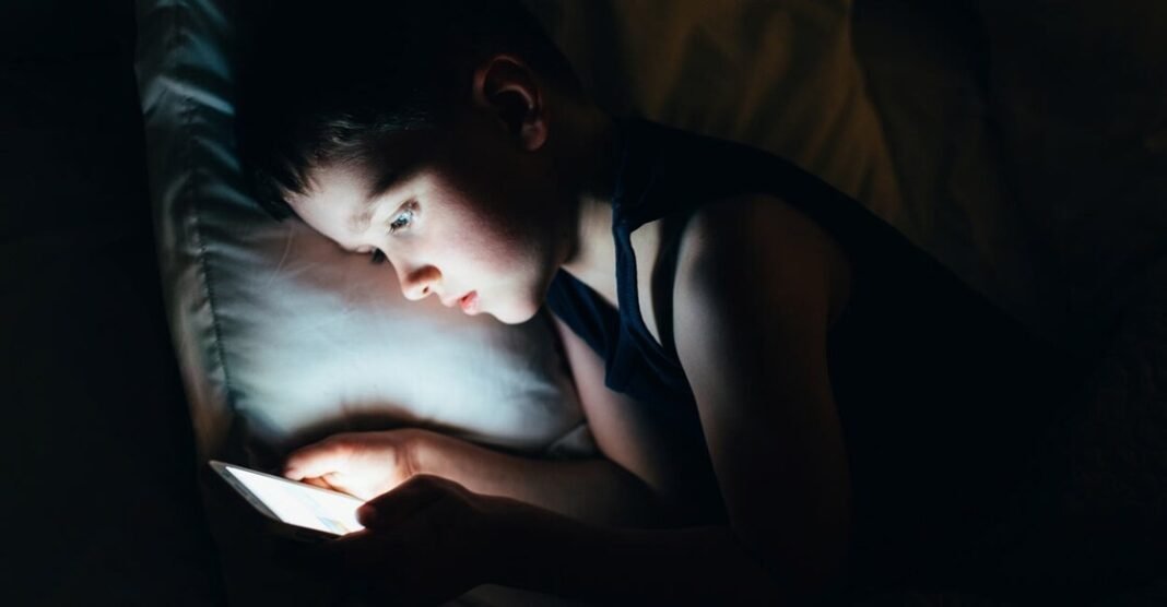 Parents using phones while children watch screens at home