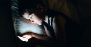 Parents using phones while children watch screens at home