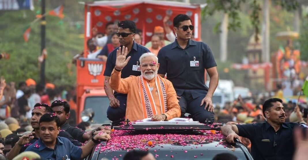 Prime Minister Narendra Modi greeting a massive crowd at a political rally in Kochi, Kerala.