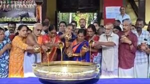 Devotees offering ghee in a traditional brass vessel (Uruli) at Arattupuzha Temple during the start of Pooram festivities.