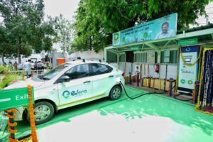 Digital illustration of an electric car charging at a station in Delhi with the India Gate in the background, symbolizing the new EV policy.