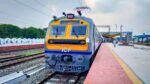 A crowded Indian Railway platform with a MEMU train prepared for Thrissur Pooram festival travelers.